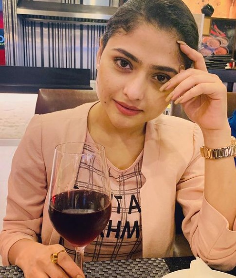 Aindrila Sharma posing with a glass of wine