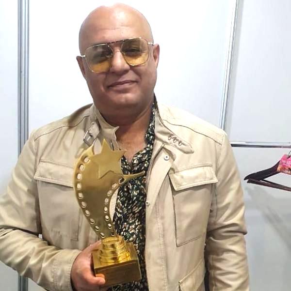 Ali Azmat posing with his Pisa Rockstar Award (2021)