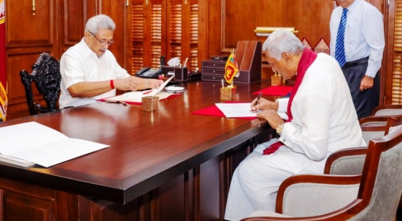 Chamal Rajapaksa signing a document in the presence of President Gotabaya Rajapaksa after being appointed as State Minister of National Security, Home Affairs, and Disaster Management