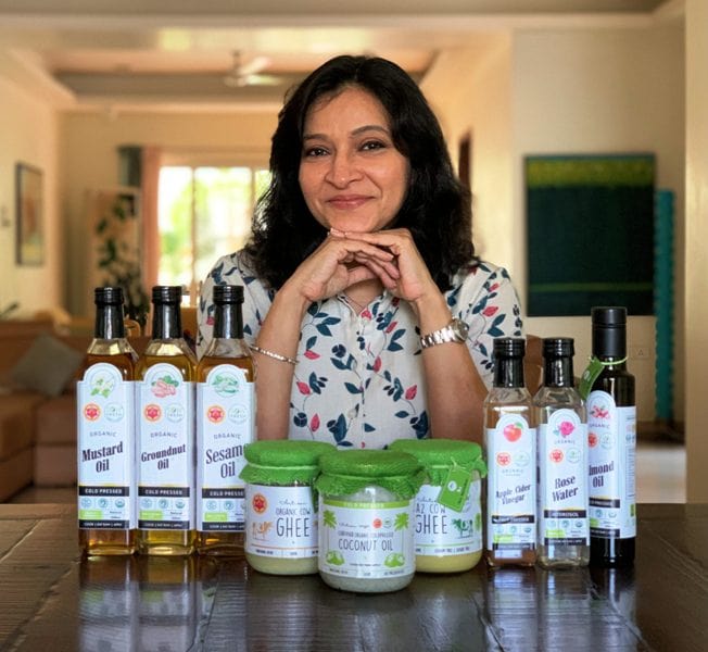 Manjula posing for a photograph with the organic products that she sells