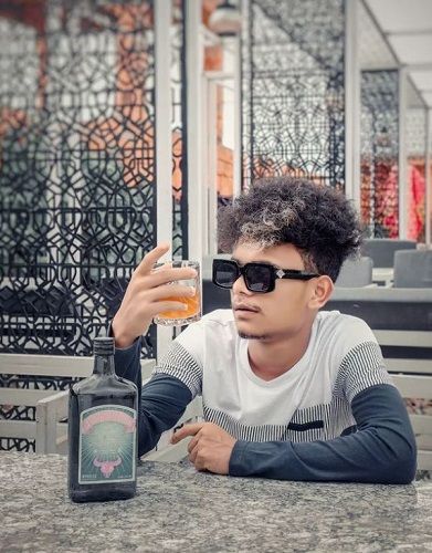 Priyanshu Kshatriya holding a glass of rum