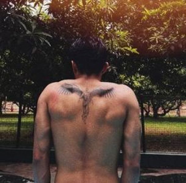A Winged Man tattoo on his back