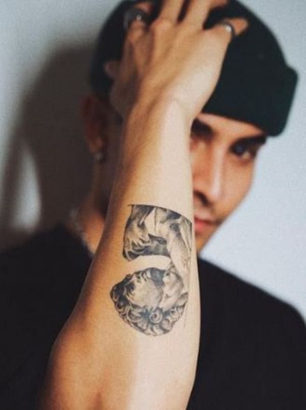 A sculpture tattoo on his left arm