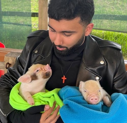 Orhan Awatramani holding piglets