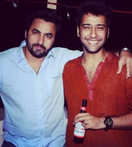 Siddharth Amit Bhavsar (right) holding a bottle of beer