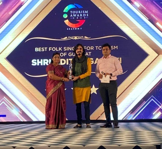 Aditya Gadhvi posing with his Best Folk Singer for Tourism Award at the Tourism Awards 2022 for his YouTube series Dhanya Dhara Gujarat