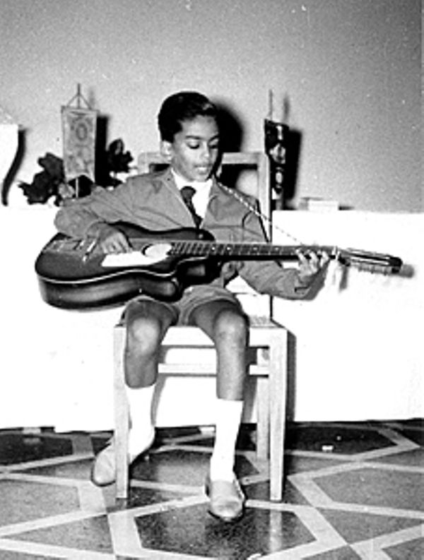 Young Remo Fernandes playing a guitar and singing
