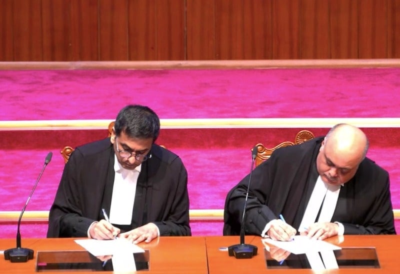 Justice Ahsanuddin Amanullah signing documents after taking oath as the judge of the Supreme Court