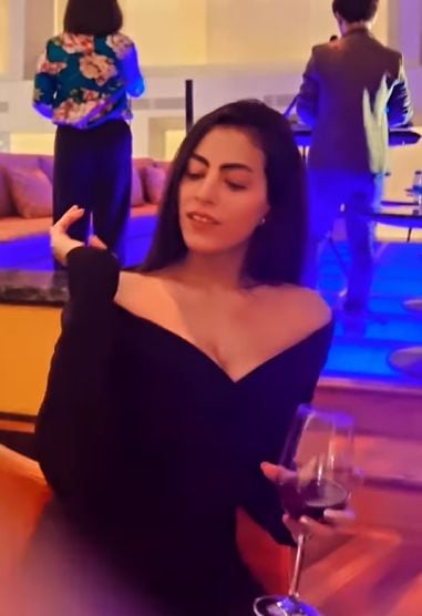 Noor holding a glass of wine