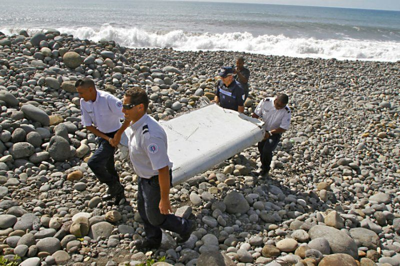 29 July 2015: French police officers while carrying a piece of debris, identified to be of Malaysia Airlines Flight 370, in Saint-André, Réunion
