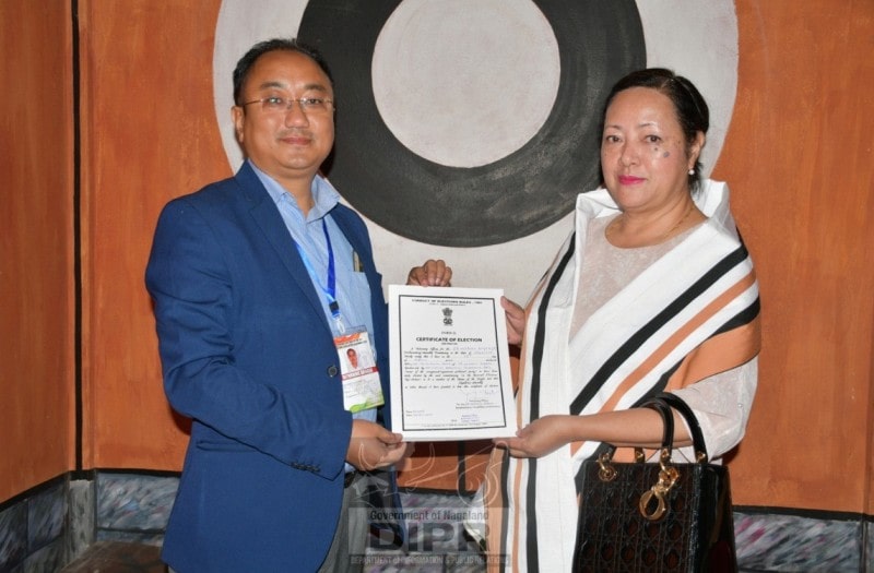 A photo of Salhoutuonuo Kruse receiving the winning certificate from the returning officer