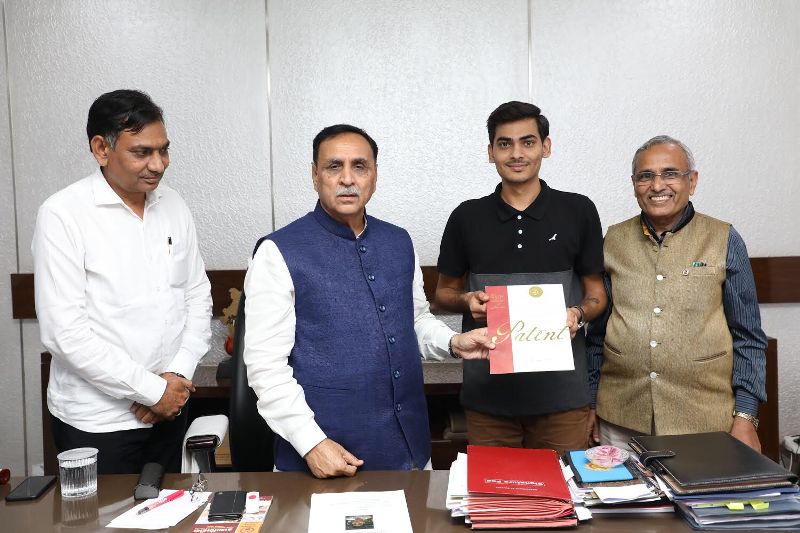 Abhijeet Satani (third from the left) showing a copy of one of his patents in the presence of Vijay Rupani (second from the left), former Chief Minister of Gujarat