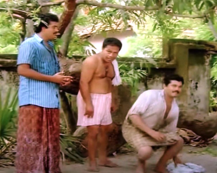 Malayalam actor Innocent as Mannar Mathai (center) in the film Ramji Rao Speaking (1989)