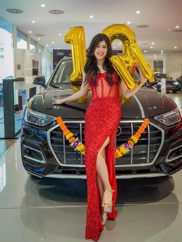 Riva Arora posing in front of her Audi car