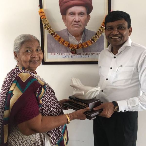 A picture of Jyantilal Gada with his mother and late father's photograph on wall