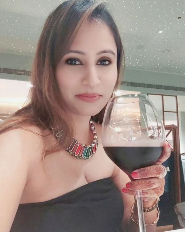 A picture of Aakshi Mathur while holding a glass of wine