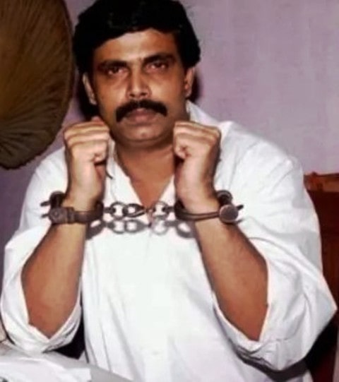 An image of Anand Mohan Singh in handcuffs