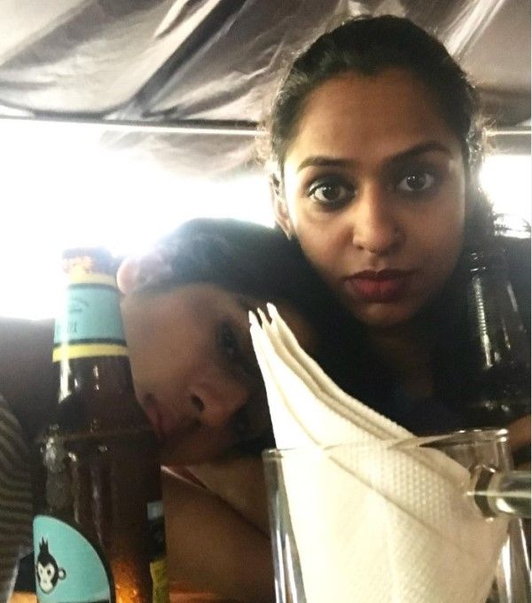 Nitya Mathur posing with a bottle of beer