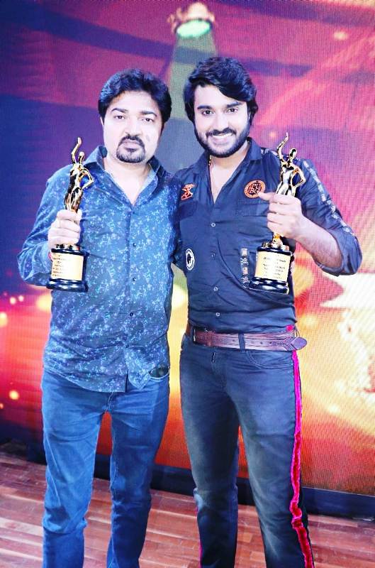 Pradeep with his father posing for a photo after receiving Bhojpuri Film Award