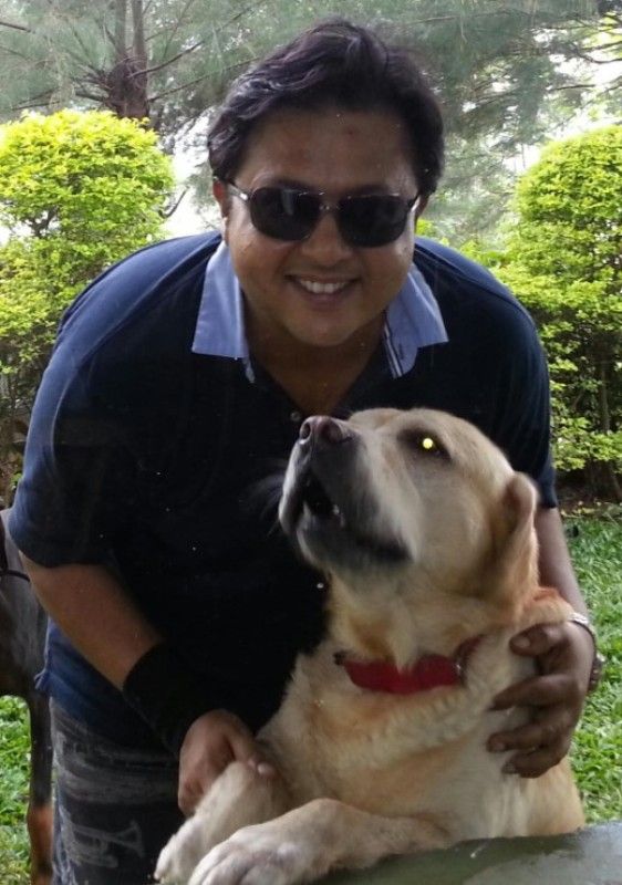 A photo of Nitesh Pandey playing with one of his three dogs