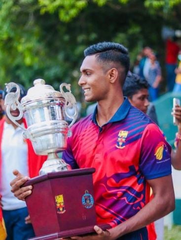 Matheesha Pathirana posing with the trophy that his school's (Trinity College) cricket team won during his last tournament for the school