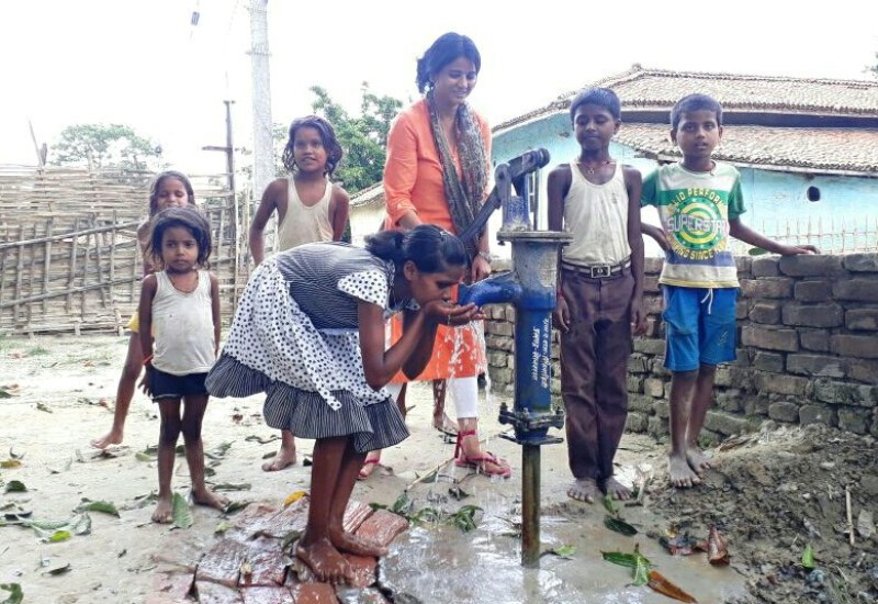 Ritu Jaiswal posing with a hand pump in Singhwahini which she successfully installed to ensure clean drinking water in the village