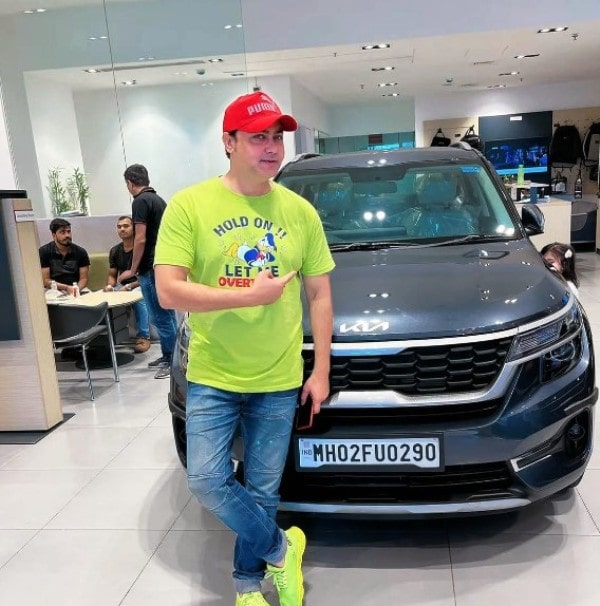 Afzaal Khan posing for a photo with his new car