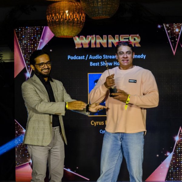 Cyrus Broacha receiving award at Indian Audio Summit & Awards 2023