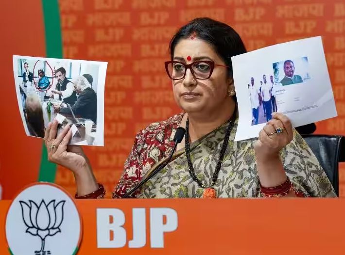 Smriti Irani, during a press conference in Delhi, showing Rahul Gandhi's pictures from his meeting with the think tanks in the US in which he can be seen sitting alongside Sunita Viswanath