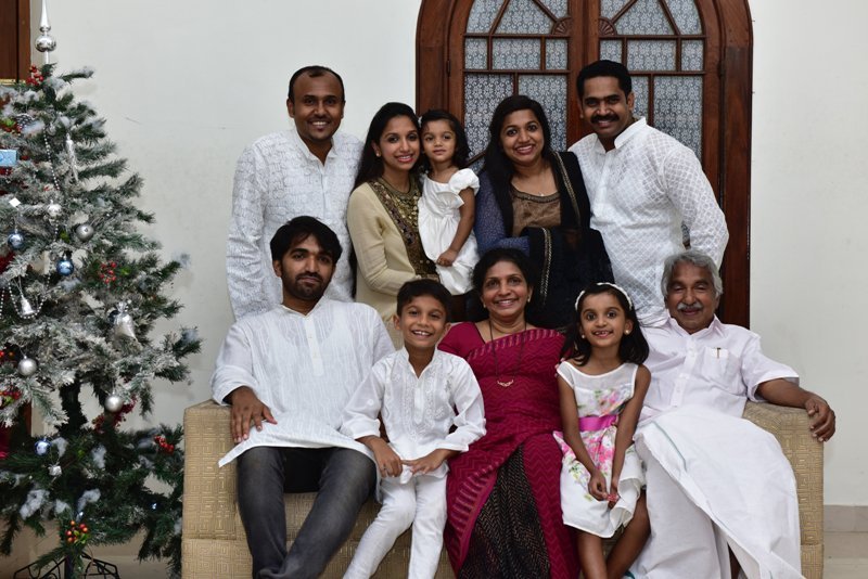 Oommen Chandy with his family on Christmas in 2015 – from left (standing): Verghese George (son-in-law), Achu (daughter), granddaughter in lap, Maria (daughter), Leejo Philip (son-in-law) – from left (sitting): Chandy Oommen (son), Mariamma Oommen (wife) with grandchildren, and Oommen Chandy