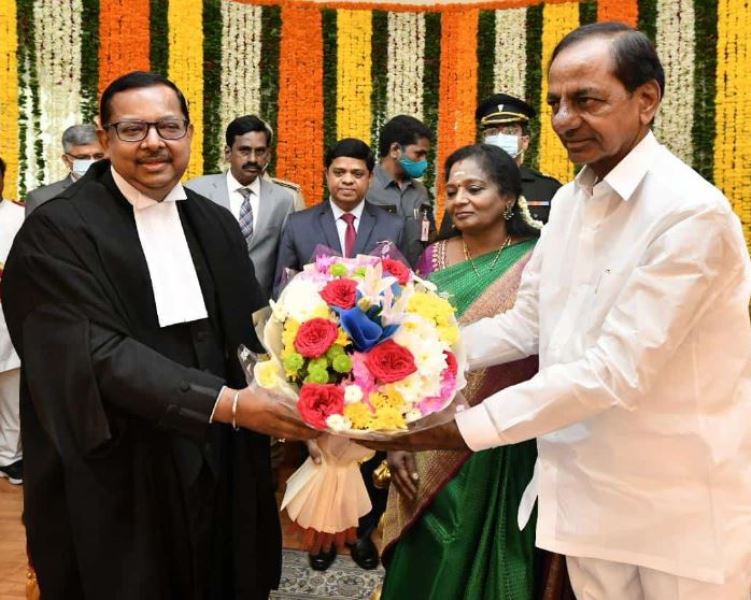 Telangana Chief Minister K Chandrashekar Rao presenting a bouquet to new Chief Justice of Telangana High Court Ujjal Bhuyan during the latter’s oath-taking ceremony on 28 June 2022