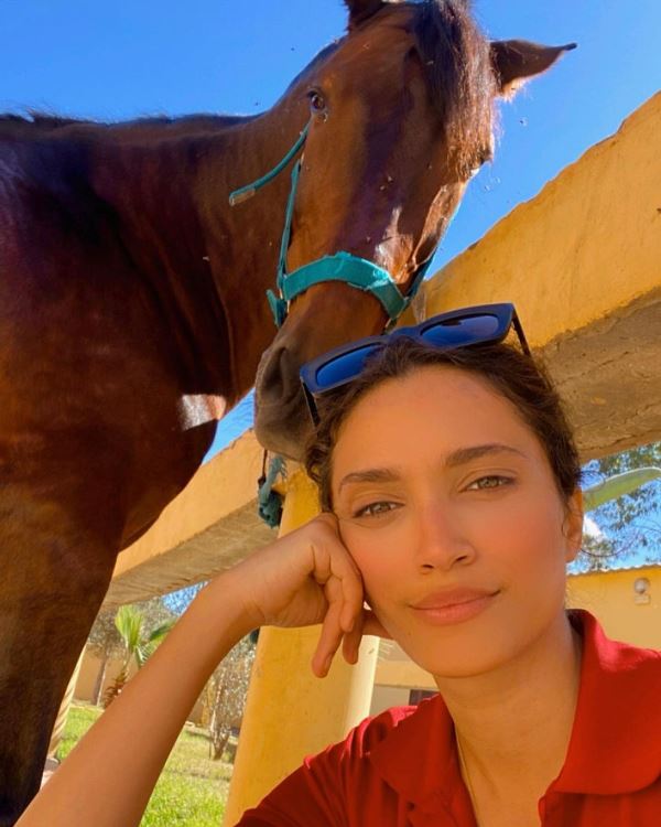 A picture of Moroccan Actress Sairi Salma posing with a horse