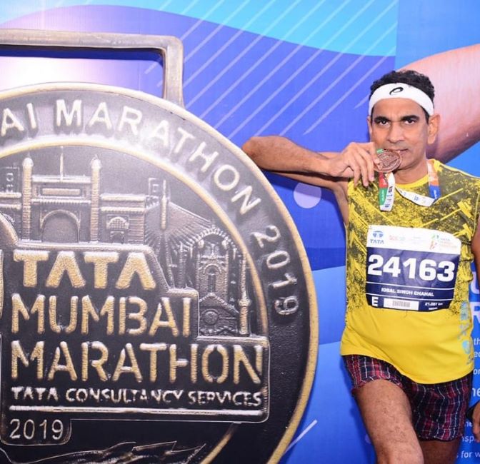 Chahal posing for a photo with his bronze medal that he won in the Mumbai Marathon in 2019