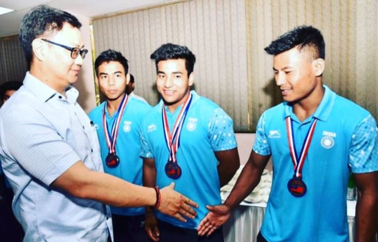 Chanambam Rishikanta Singh (extreme right) after winning a medal at a weightlifting competition