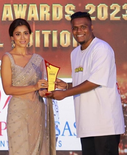 Harry D Cruz receiving an award from Shriya Saran