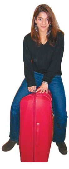 Koel Purie posing with her red suitcase