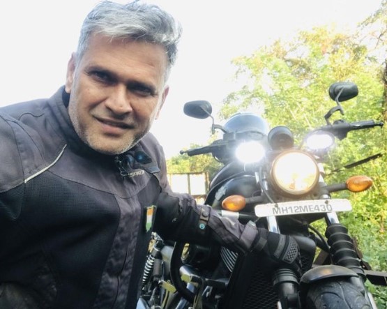 Sameer posing with his Harley Davidson