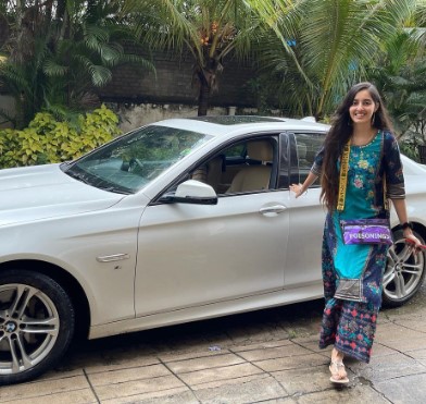 Simrat Kaur posing with her BMW