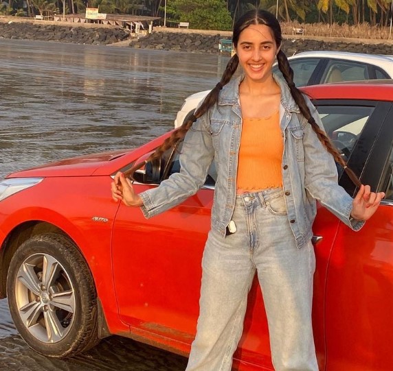 Simrat Kaur posing with her Mazda 3 Sedan