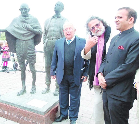 Yusuf Hamied posing with the statues of Mahatma Gandhi and Hermann Kallenbach in Vilnius
