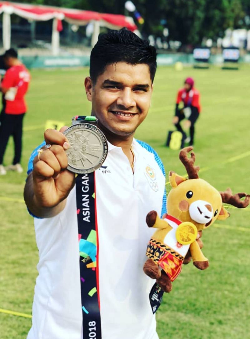 Abhishek Verma posing with silver medal in compound team event