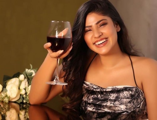 Ayra Bansal holding a glass of red wine