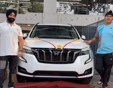 A picture of Jasmine Kaur's husband and their son with Mahindra SUV