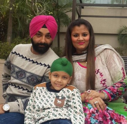 Jasmine Kaur posing with her husband and son