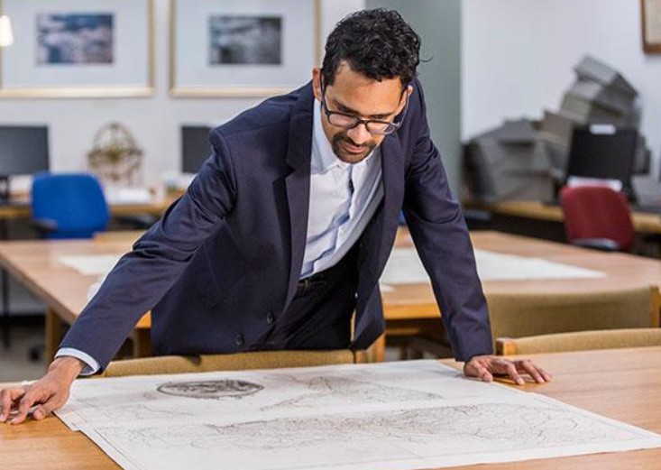 Sunil Amrith while studying a map