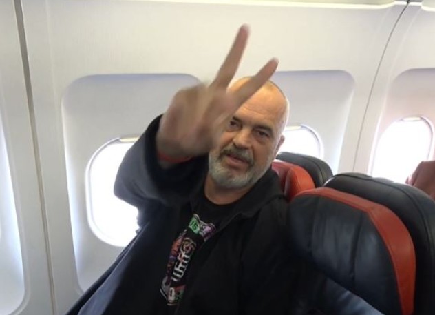 Edi Rama while showing a victory sign on a Lufthansa flight in 2021