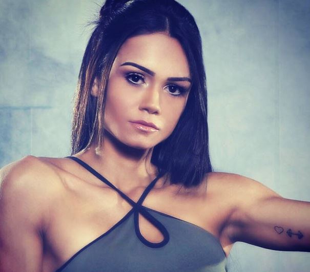 Heart and dumbbell tattoo inside left bicep of Diana Areas