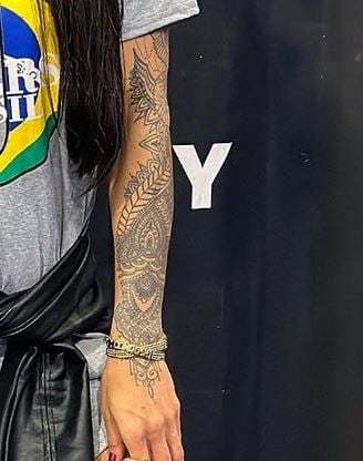 Tattoos on Diana Areas' left arm