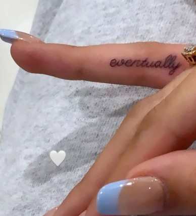 Madison Beer's Eventually tattoo on the inner side of her right hand ring finger