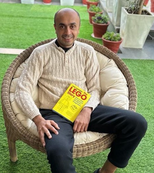 Albinder Singh Dhindsa posing with a book